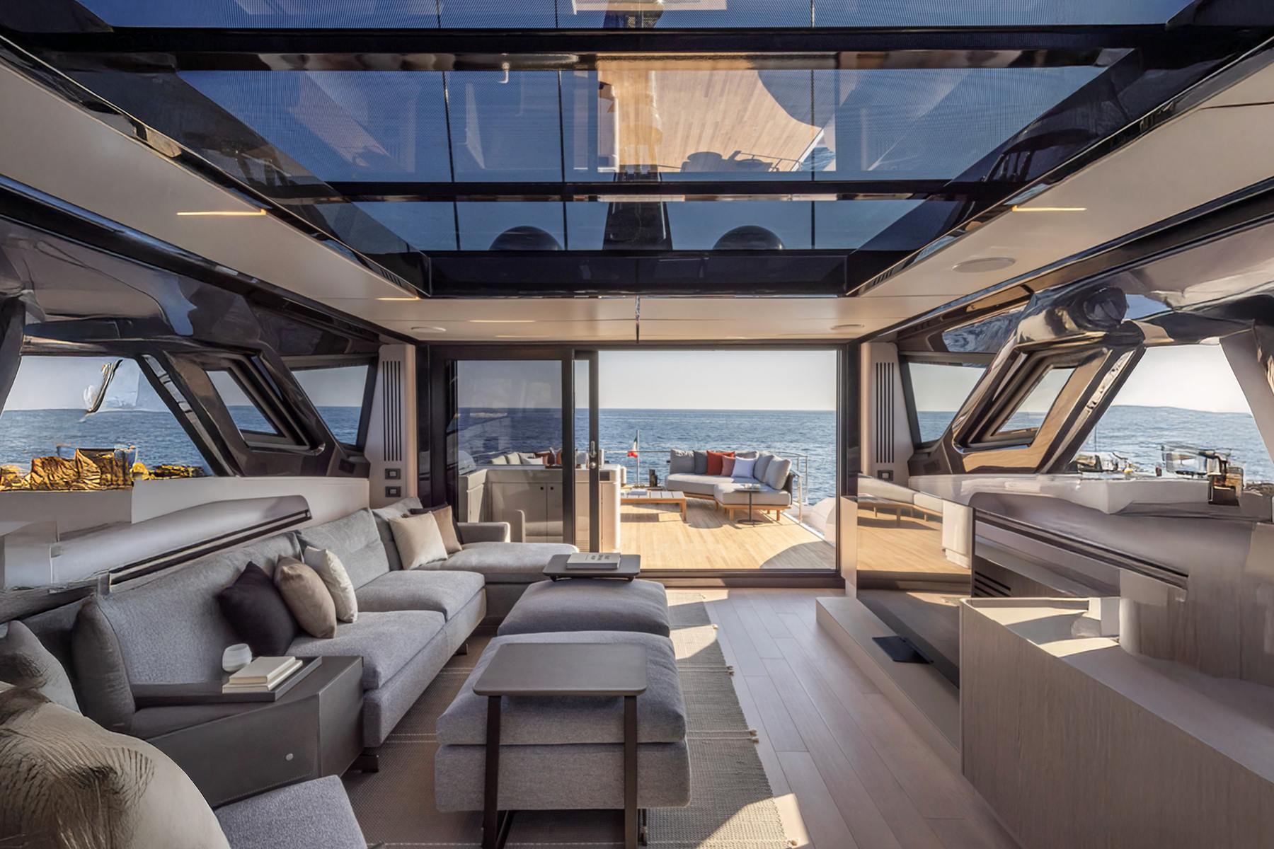 Sky lounge under a glass roof, looking aft through the open side windows to the deck and the water.